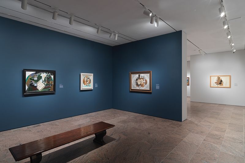 Wide photograph of a gallery with cubist works. 