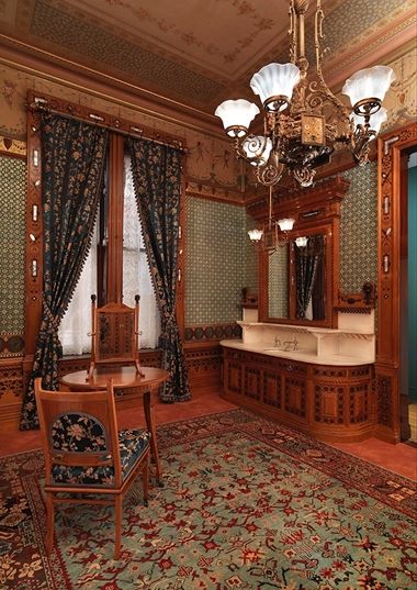 Interior view of the Worsham-Rockefeller Dressing Room at The Met with a chair, dressing table and mirror, and a sink.
