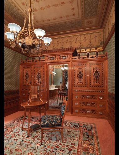 Historic interior at The Met with late-19th-century chair, dressing table, mirror, wood paneling, and wall decor