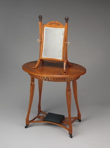 A late-19th-century ovular dressing table and mirror made from a light/medium colored wood. 