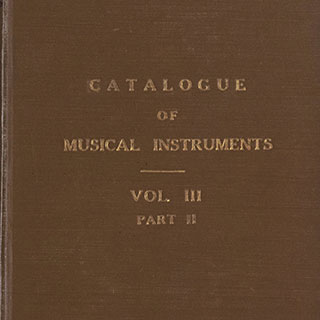 Detail of a brown cloth bound volume with the words "CATALOGUE OF MUSICAL INSTRUMENTS VOL. III PART II" stamped in gold