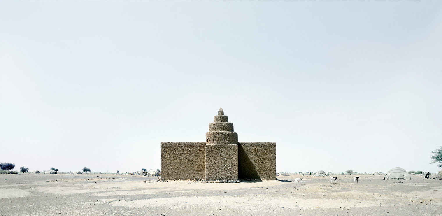 A low mud mosque in the middle of an arid desert