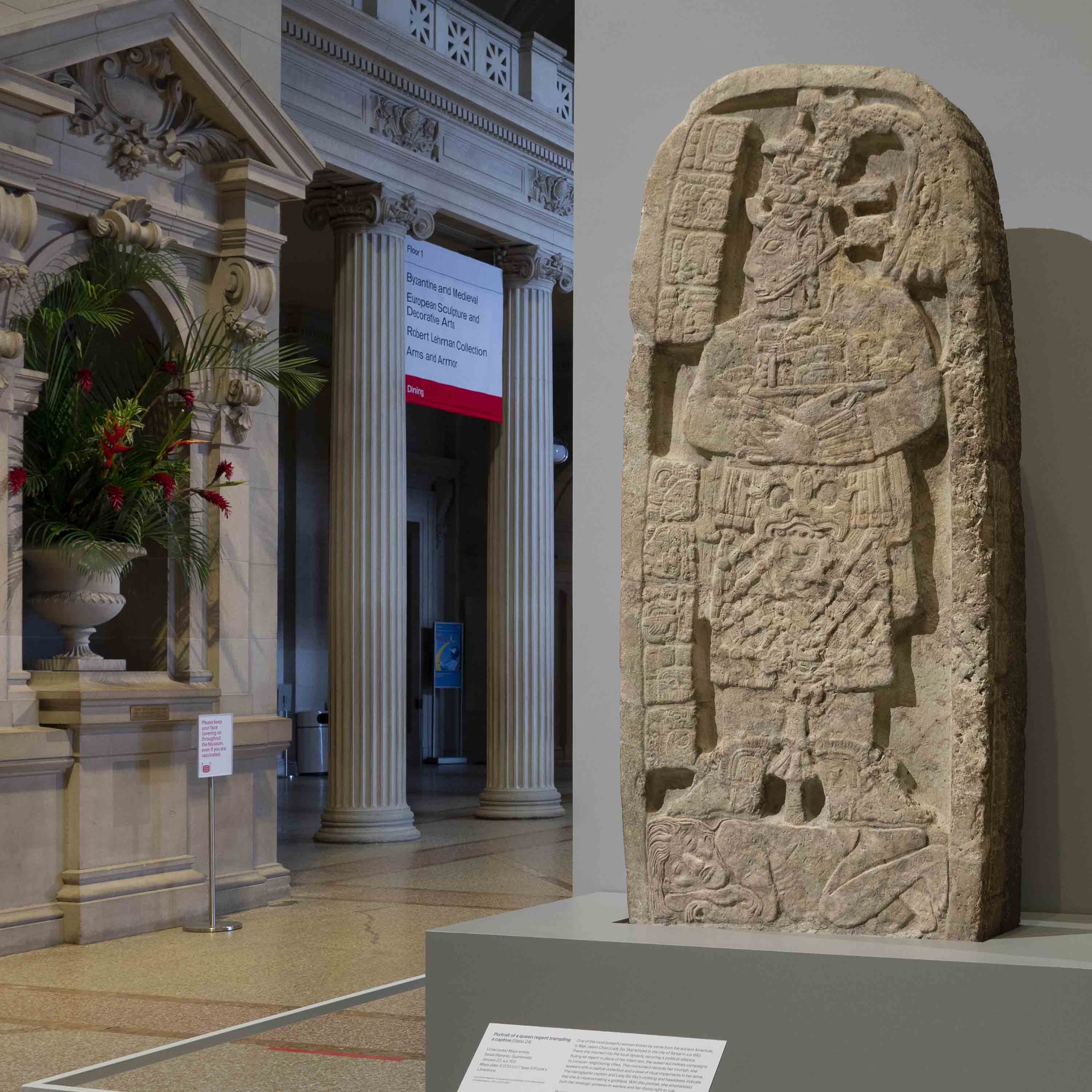 Portrait of a queen regent trampling a captive carved into a stelae, or large decorated stone slab, of Maya origin. The sculpture is installed in the Great Hall at the Museum.
