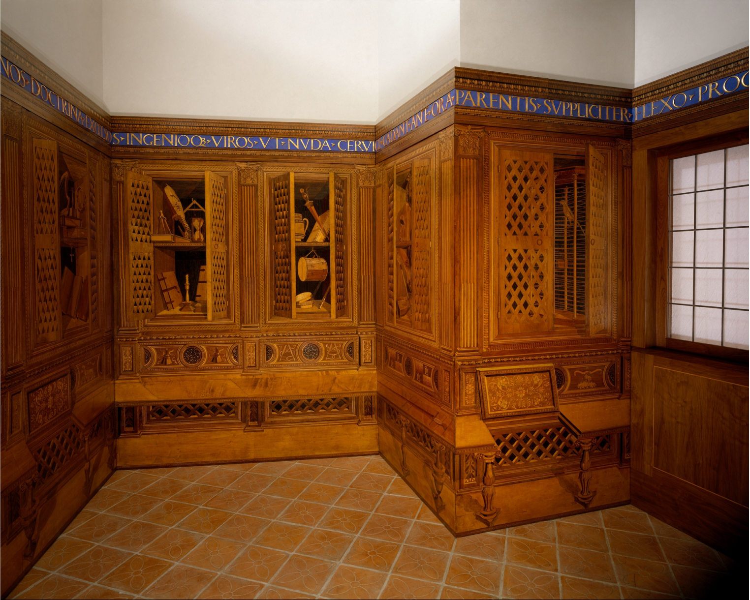 A studio of walls carried out in a wood-inlay technique known as intarsia. The studio showcases cabinets, books and objects reflecting Duke Federico's wide-ranging artistic and scientific interests.