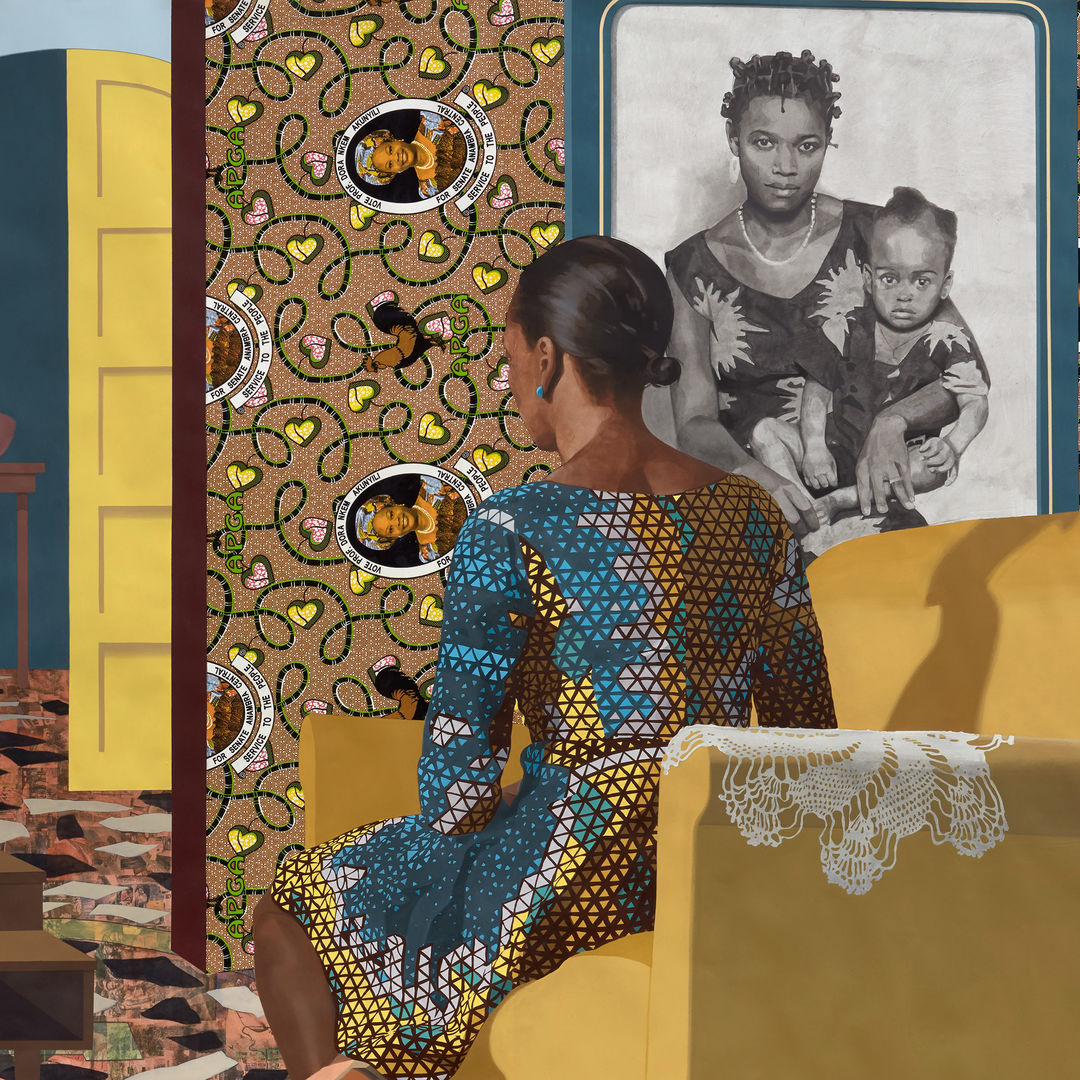 A woman in a multicolored dress is seated on a yellow couch, her back to the viewer. In the background at right is a black and white portrait of a mother holding a baby. The room is characterized by whimsical and geometric designs, including portraits as part of the wallpaper.